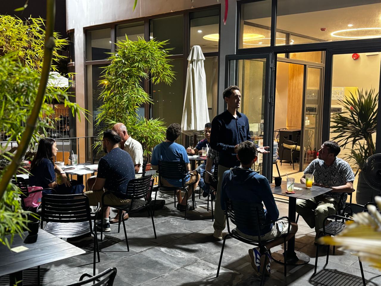 Members sitting at multiple cafe tables during the Friday, April 24, 2026 structured language exchange in Da Nang.